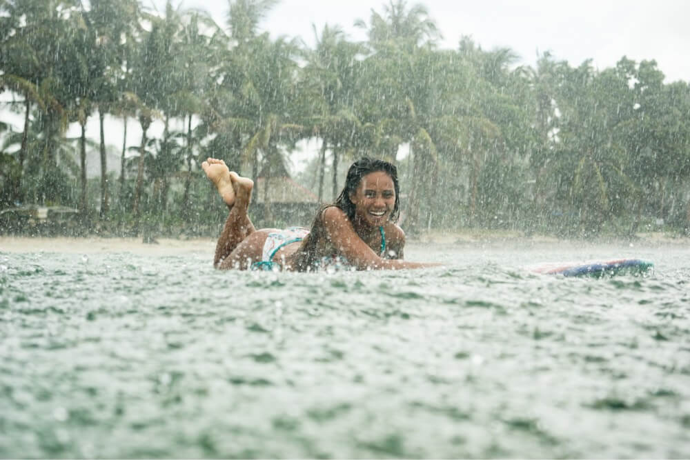 Surfer, Ikit Agudo paddling in the rain