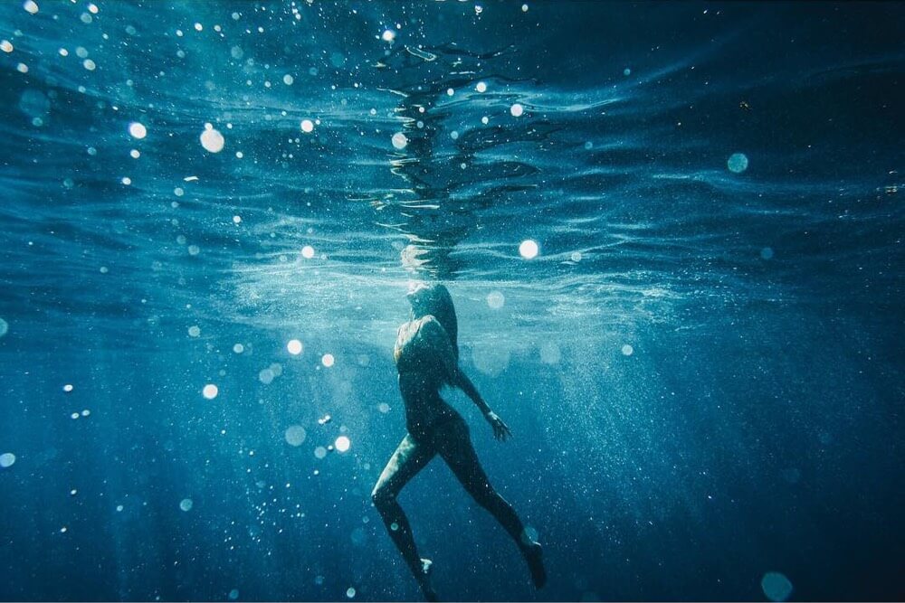 Woman swimming to ocean surface
