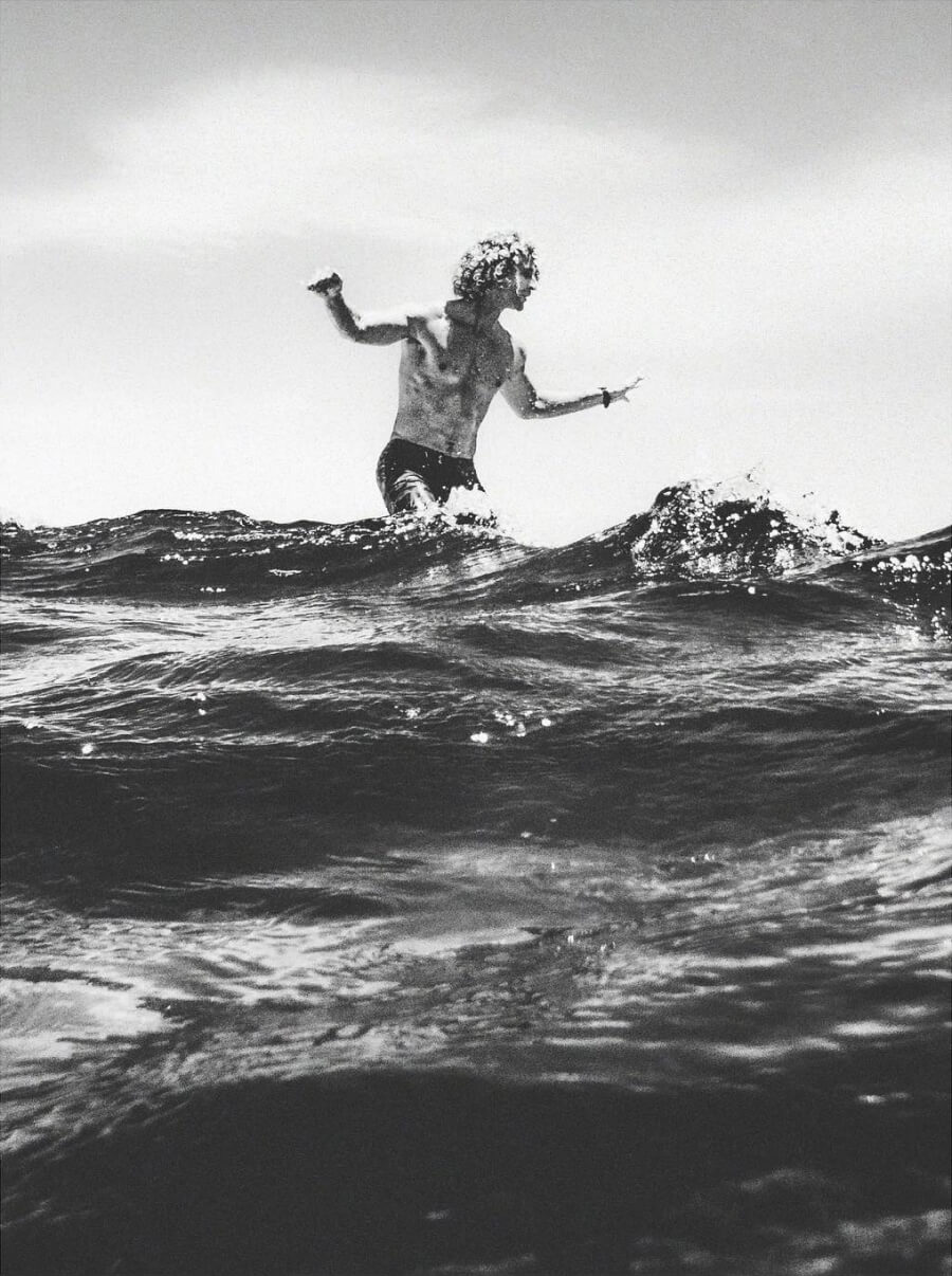 Black and white photo of surfer above a wave