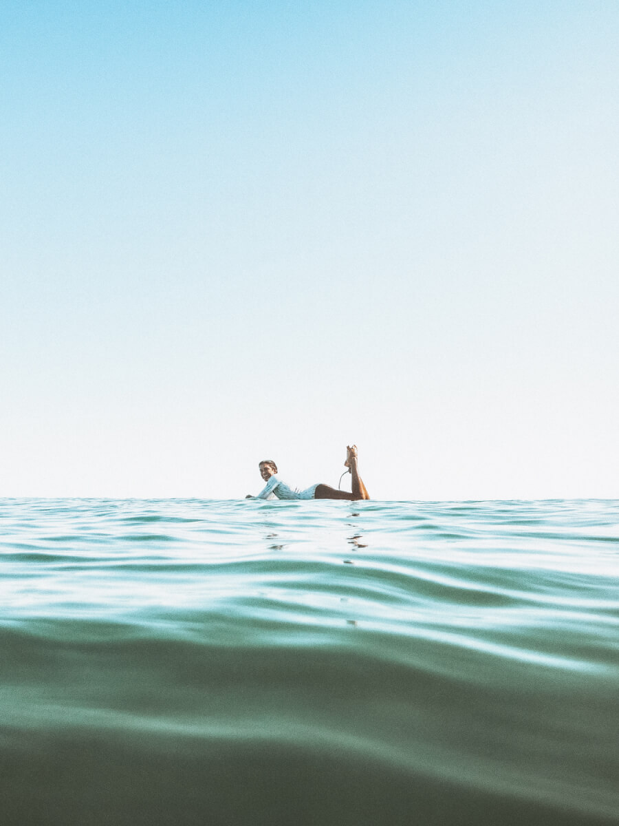 Female surfer lying on surfboard
