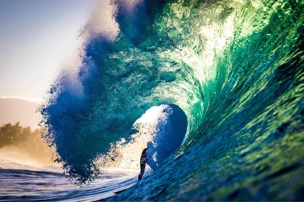 Surfer from behind in the barrel of a wave