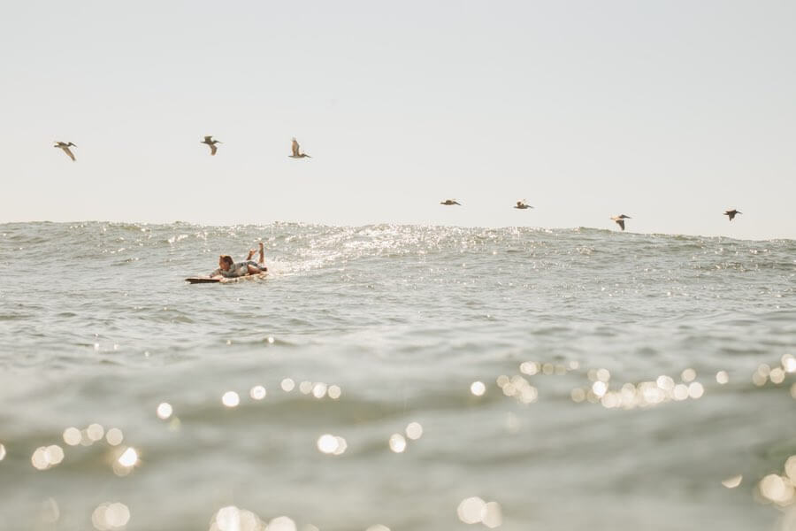 Surfer girl paddling on surfboard