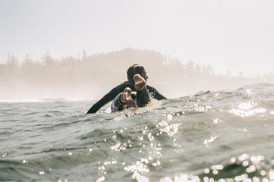 Surfer girl paddling