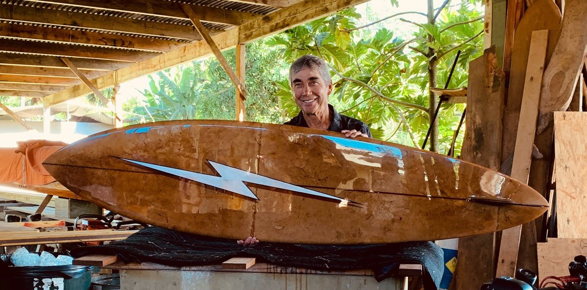 Gerry Lopez with the 2018 Pipe Masters trophy surfboard featuring art by Phil Roberts