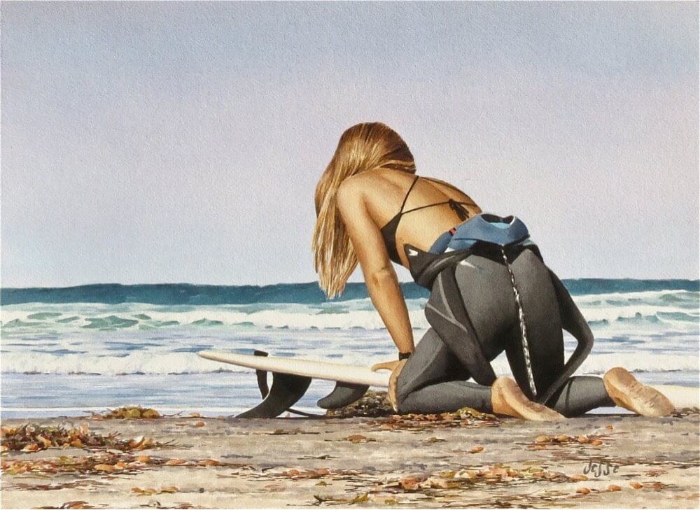 Surfer girl waxing her surfboard