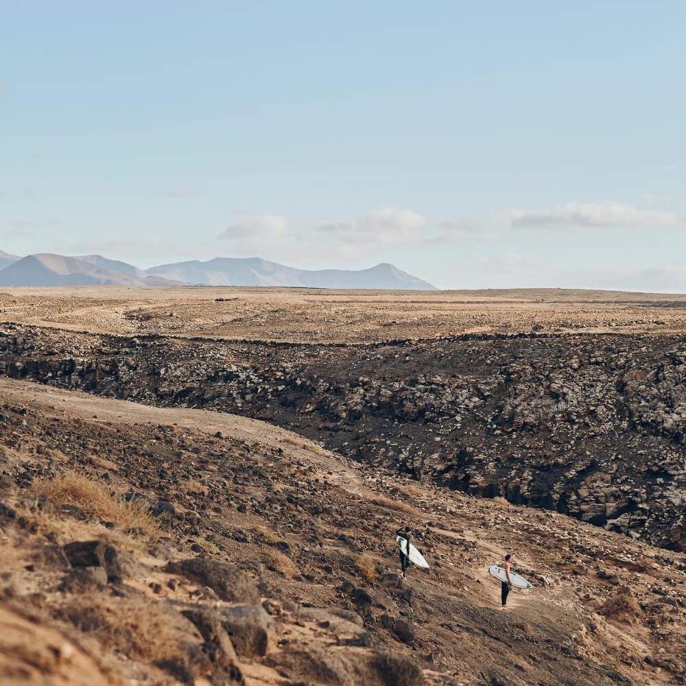 Surfers in a desert landscape
