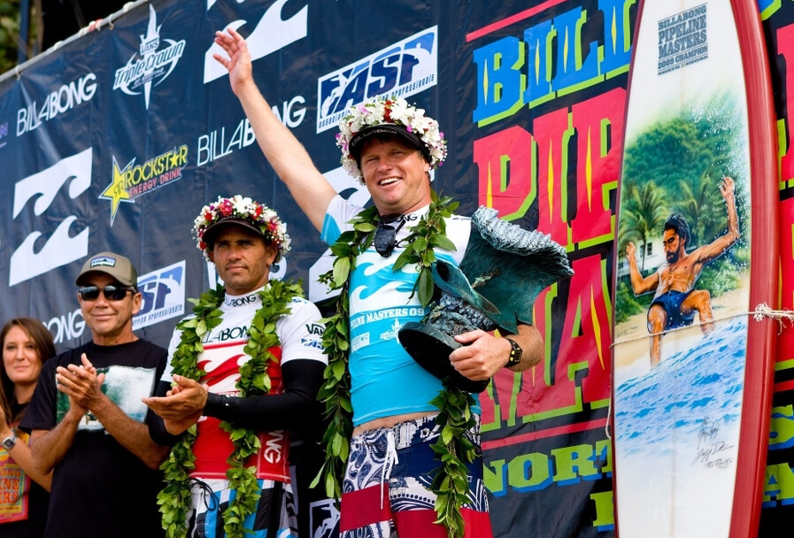 2009 Pipe Masters winner, Taj Burrow with runner-up Kelly Slater, Gerry Lopez, and the trophy surfboard by Phil Roberts