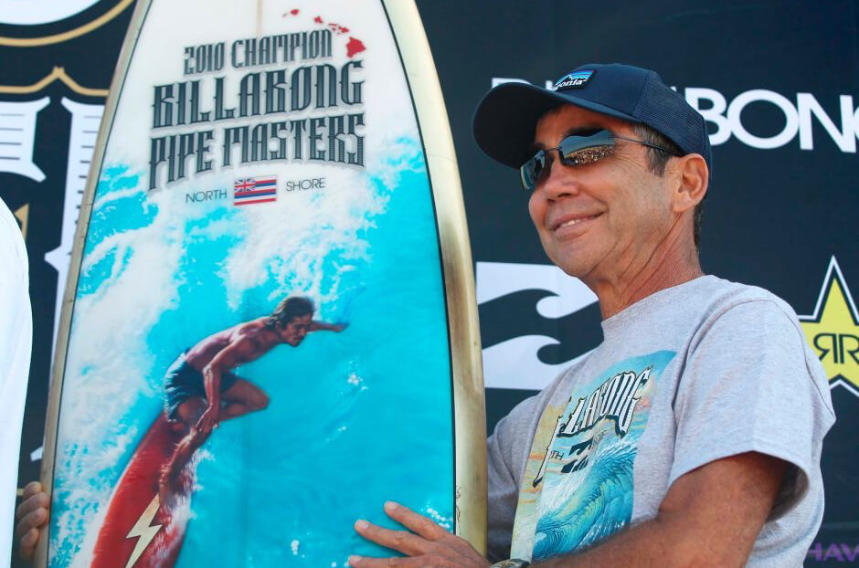 Gerry Lopez with the 2010 Pipe Masters trophy surfboard featuring art by Phil Roberts