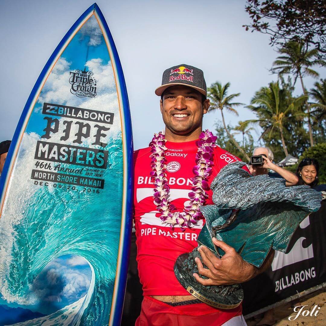 2016 Pipe Masters winner, Michel Bourez with the Pipe Masters trophy and surfboard by Phil Roberts