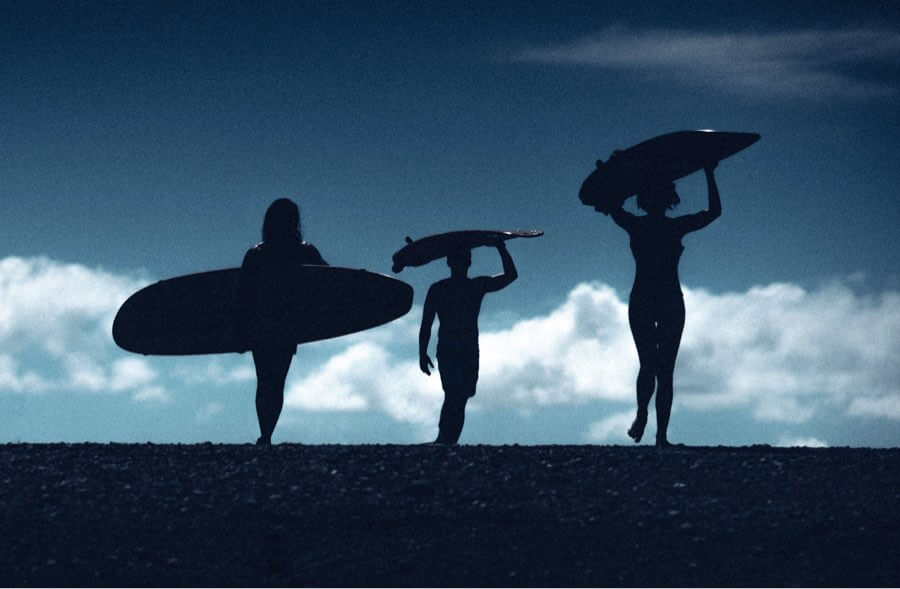 Silhouetted surfers