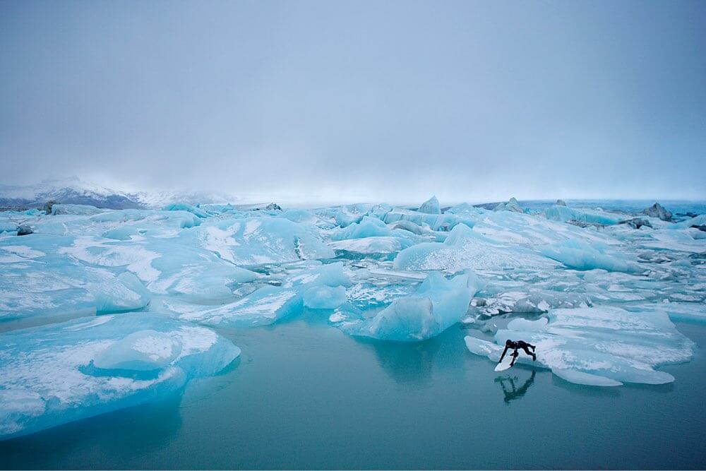 Surfer diving into icy water